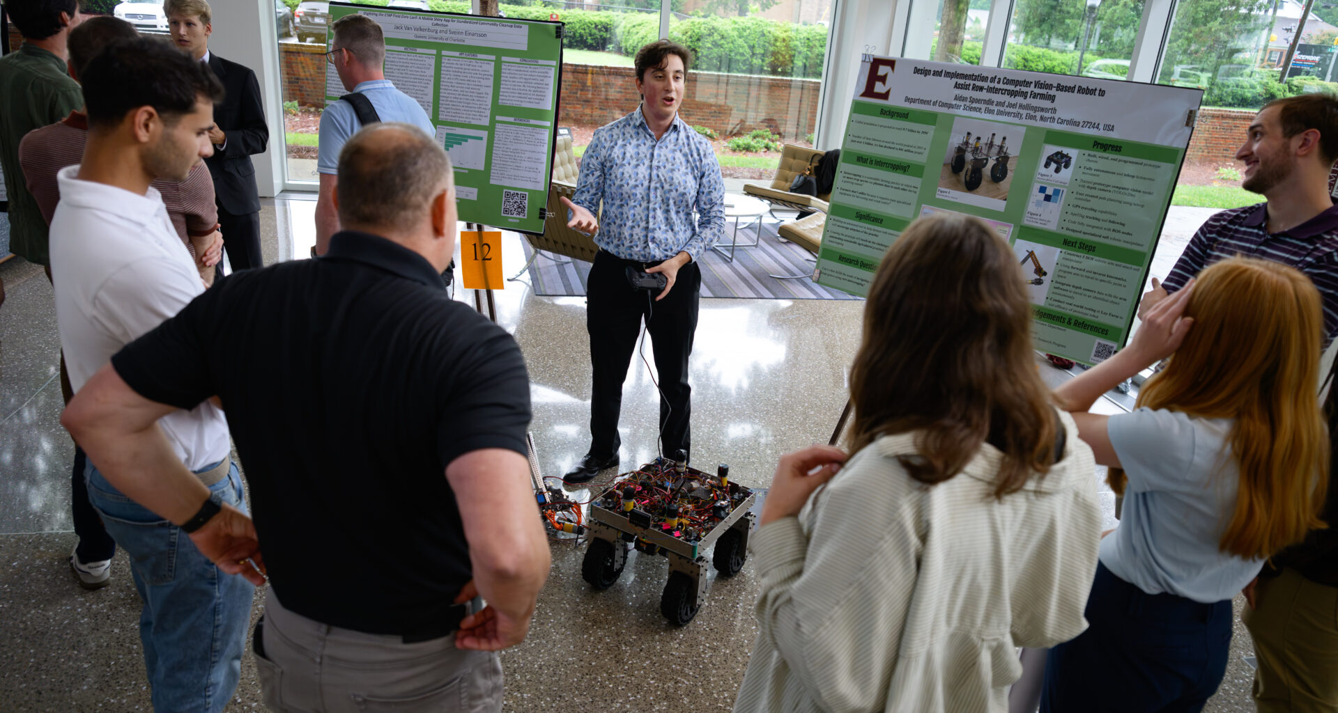 An Elon University student demonstrates a computer vision-based robot designed to assist with intercropping farming during the Summer Undergraduate Research Experience presentations.