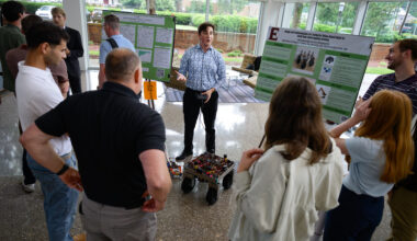 An Elon University student demonstrates a computer vision-based robot designed to assist with intercropping farming during the Summer Undergraduate Research Experience presentations.