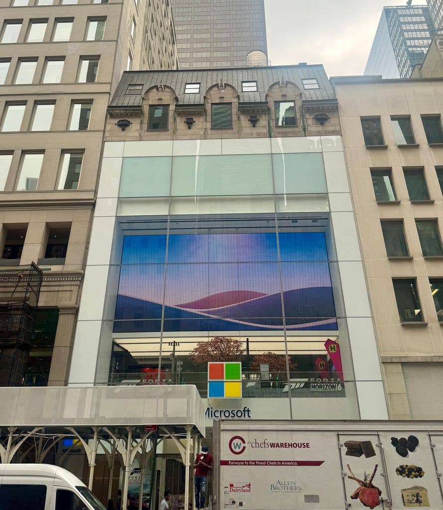 Microsoft Fifth Avenue store exterior, a former Vanderbilt townhouse, with large glass windows and logo. 