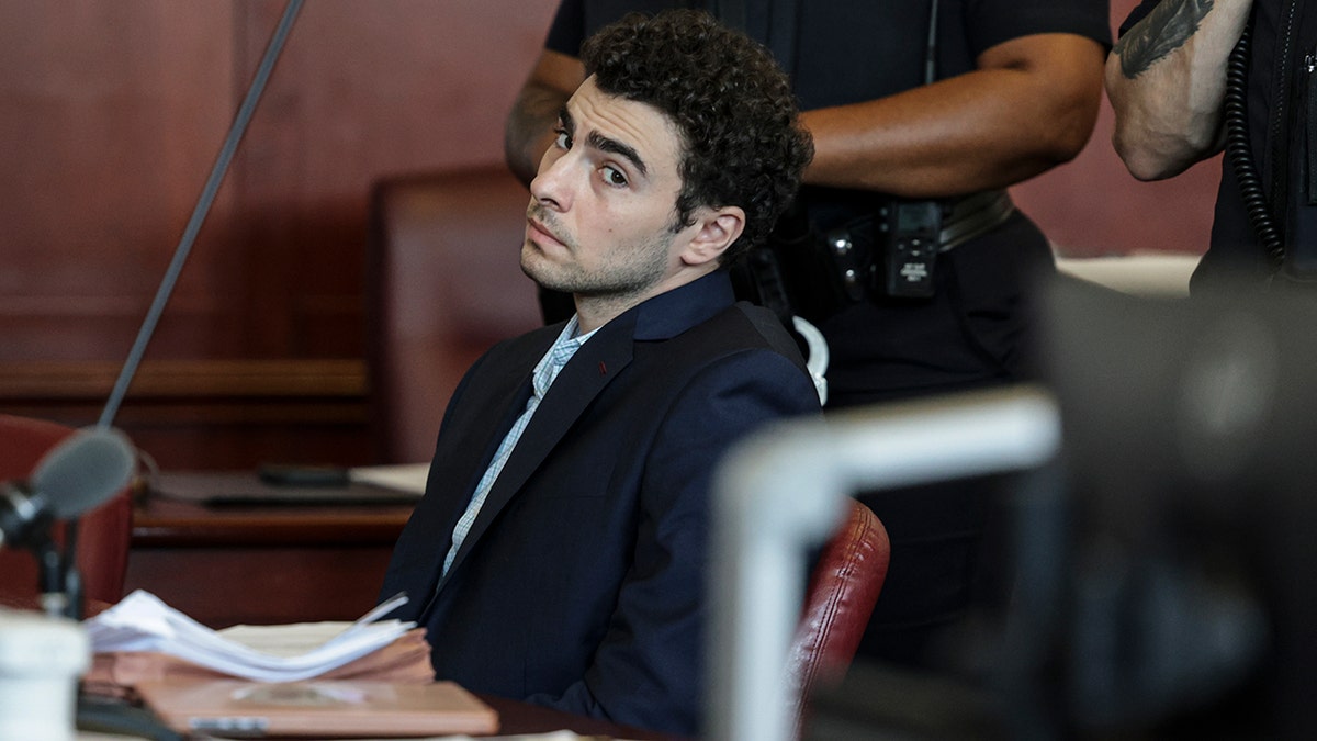 Luigi Mangione appearing at an evidence suppression hearing in a courtroom.