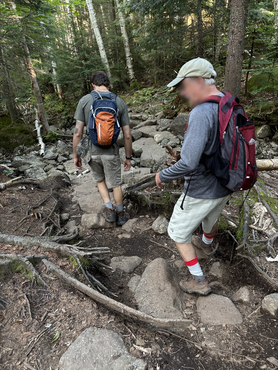 Two people hike along some rocks