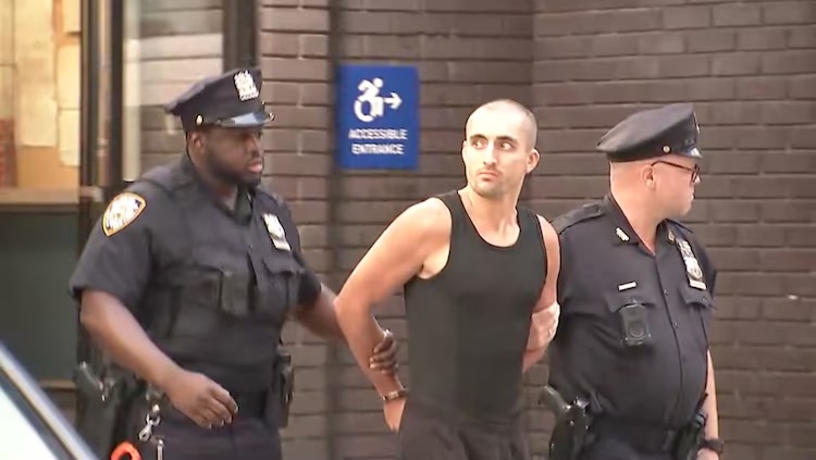 Ivan Kuznetsov, who is also known as Ivan Beerkus, is seen being escorted out of a Manhattan police station, July 1, 2026.