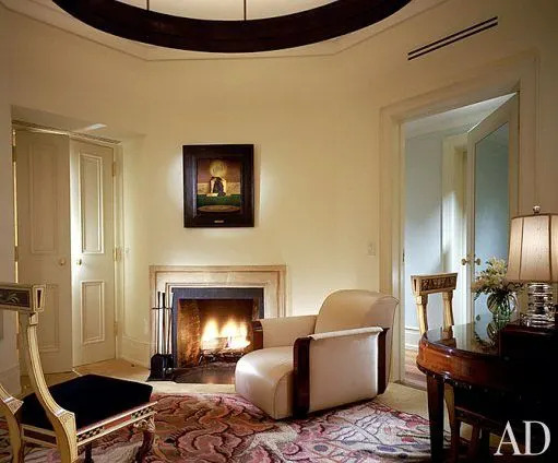Another oval ceiling light softens the angles of the six-sided dressing room. Over the fireplace is The Young King of the Black Isles, 1906, by Maxfield Parrish. The Art Deco armchair is attributed to Michel Dufet and the dressing table to Paul Follot. The 1920s rug is signed “P. Laconte.” Edward Fields carpet.