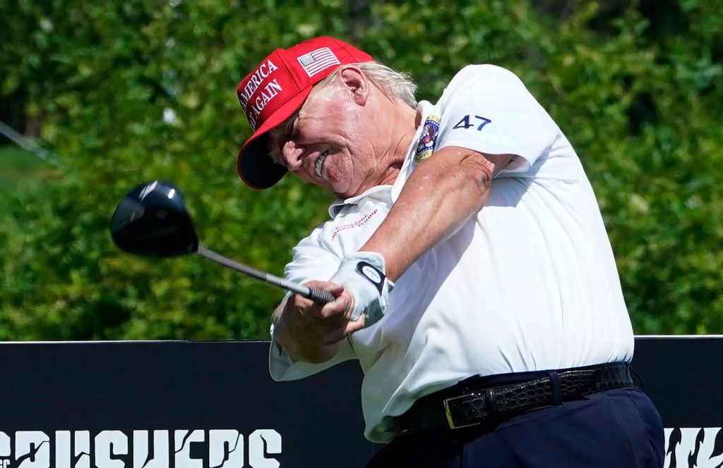 Former US President Donald Trump golfing with a driver.
