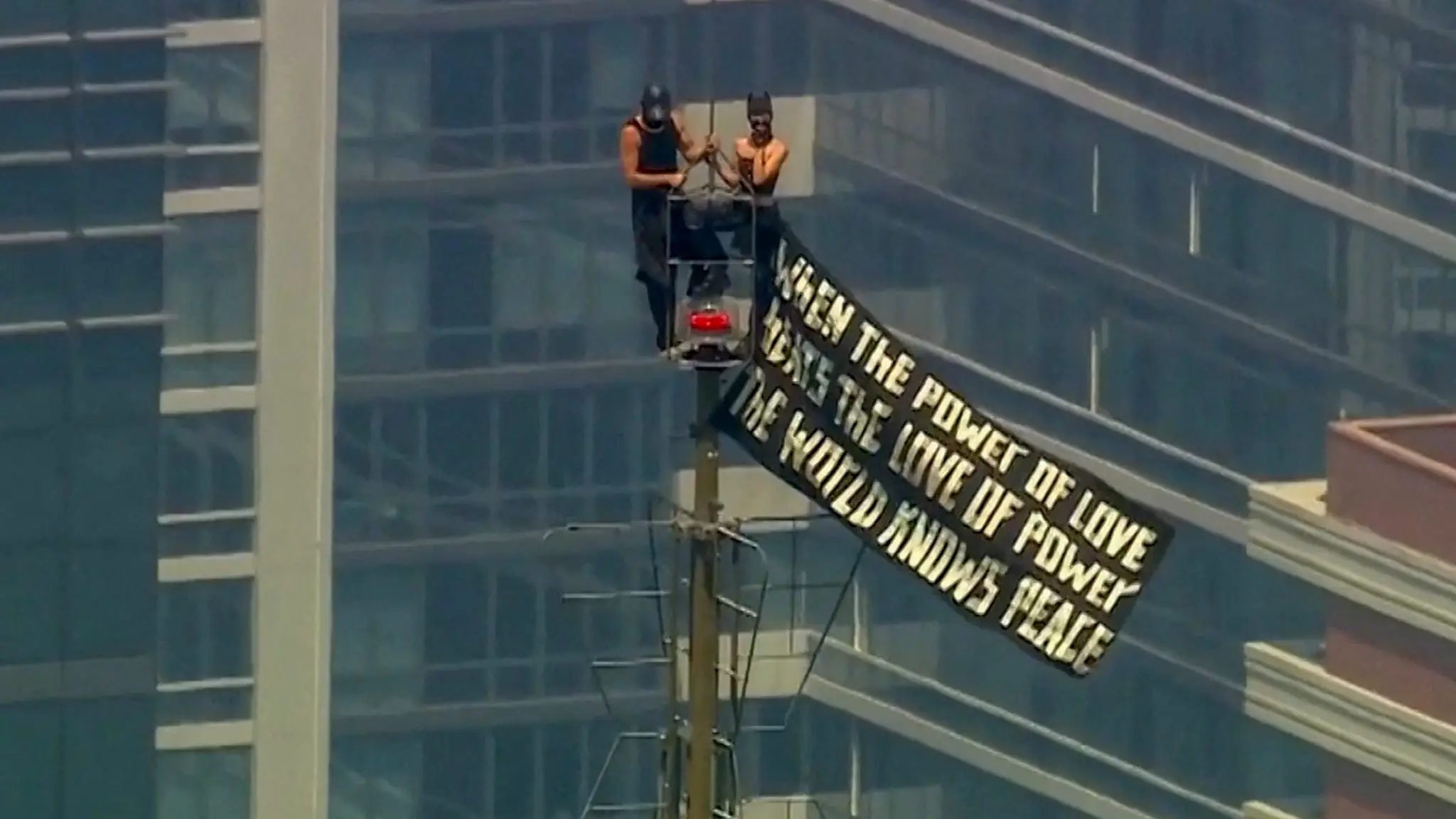 two-people-display-a-banner-atop-the-empire-state-building-in-the-manhattan-borough-of-new-york