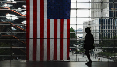 A shopper walks past a U.S. flag at Hudson Yards in New York City