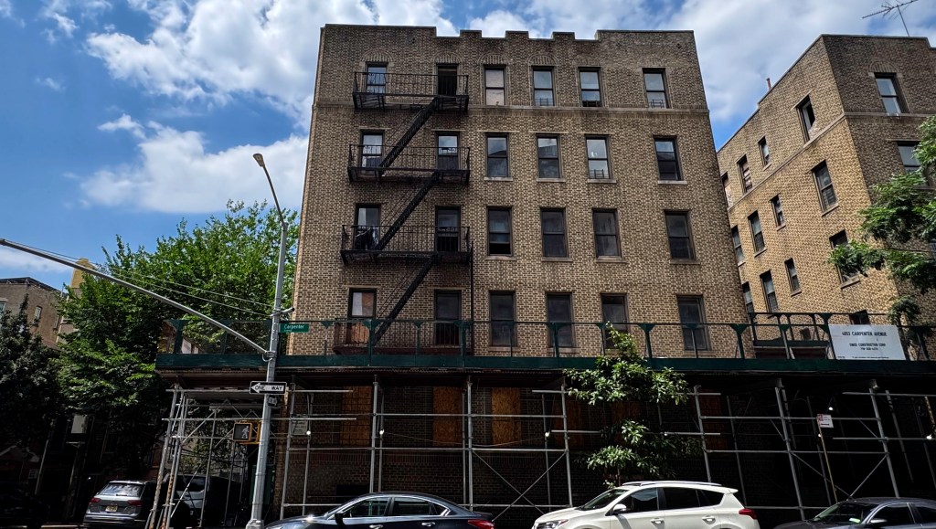 Building at 4053 Carpenter Avenue in the Bronx, NY, with scaffolding covering the lower levels and a street sign for Carpenter Avenue.