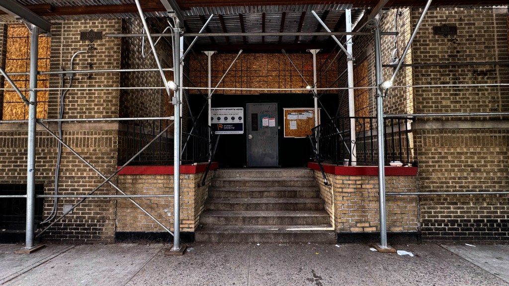 Scaffolding surrounds the entrance of a building at 4053 Carpenter Avenue in the Bronx.