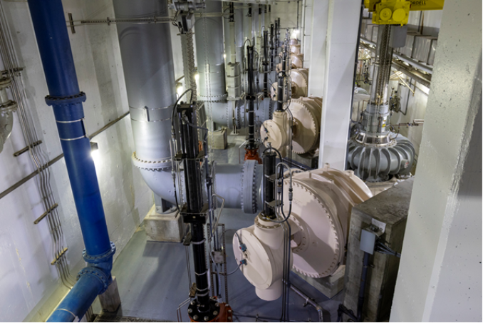 Force mains and pumps inside a large industrial room