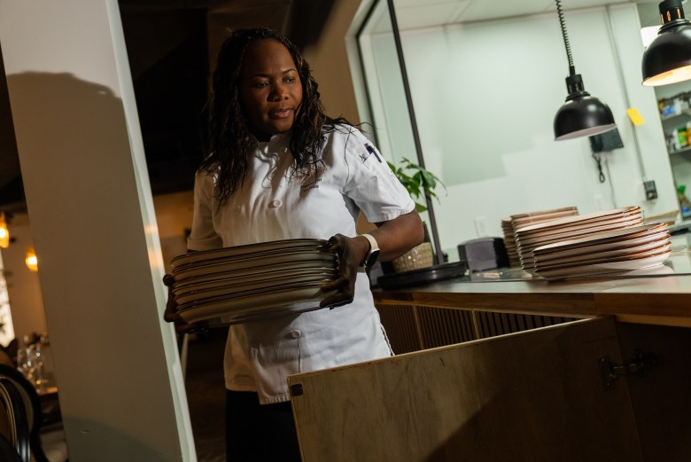 Chef Eva Volmar moves dishes before service at La Cachette du Coin, 625 Rogers Avenue, Brooklyn on Thursday, May 14, 2026. Photo by Allison Hunter for The Haitian Times. 
