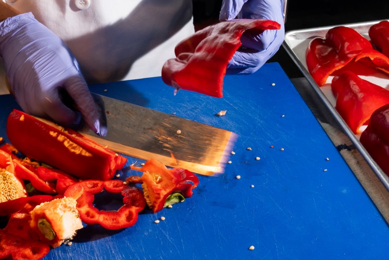 Chef Eva Volmar preps red peppers at La Cachette du Coin, 625 Rogers Avenue, Brooklyn on Thursday, May 14, 2026. Photo by Allison Hunter for The Haitian Times. 
