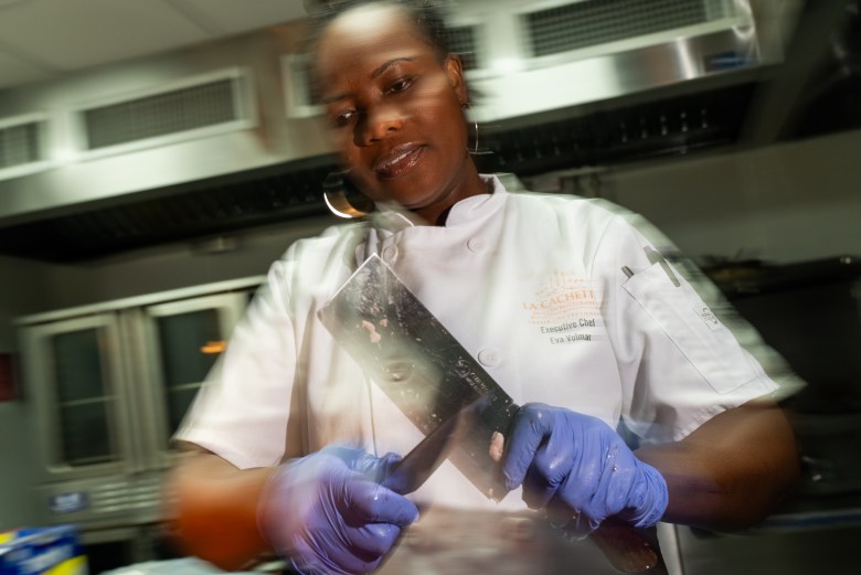 Chef Eva Volmar sharpens a cleaver at La Cachette du Coin, 625 Rogers Avenue, Brooklyn on Thursday, May 14, 2026. Photo by Allison Hunter for The Haitian Times. 

