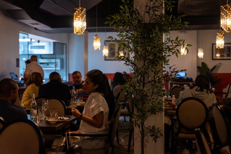 The dining room of La Cachette du Coin, where Volmar paid $8,000 out of pocket for carpeting after her contractor refused to complete the flooring, at 625 Rogers Avenue in Brooklyn on Friday, May 29, 2026. Photo by Allison Hunter for The Haitian Times. 
