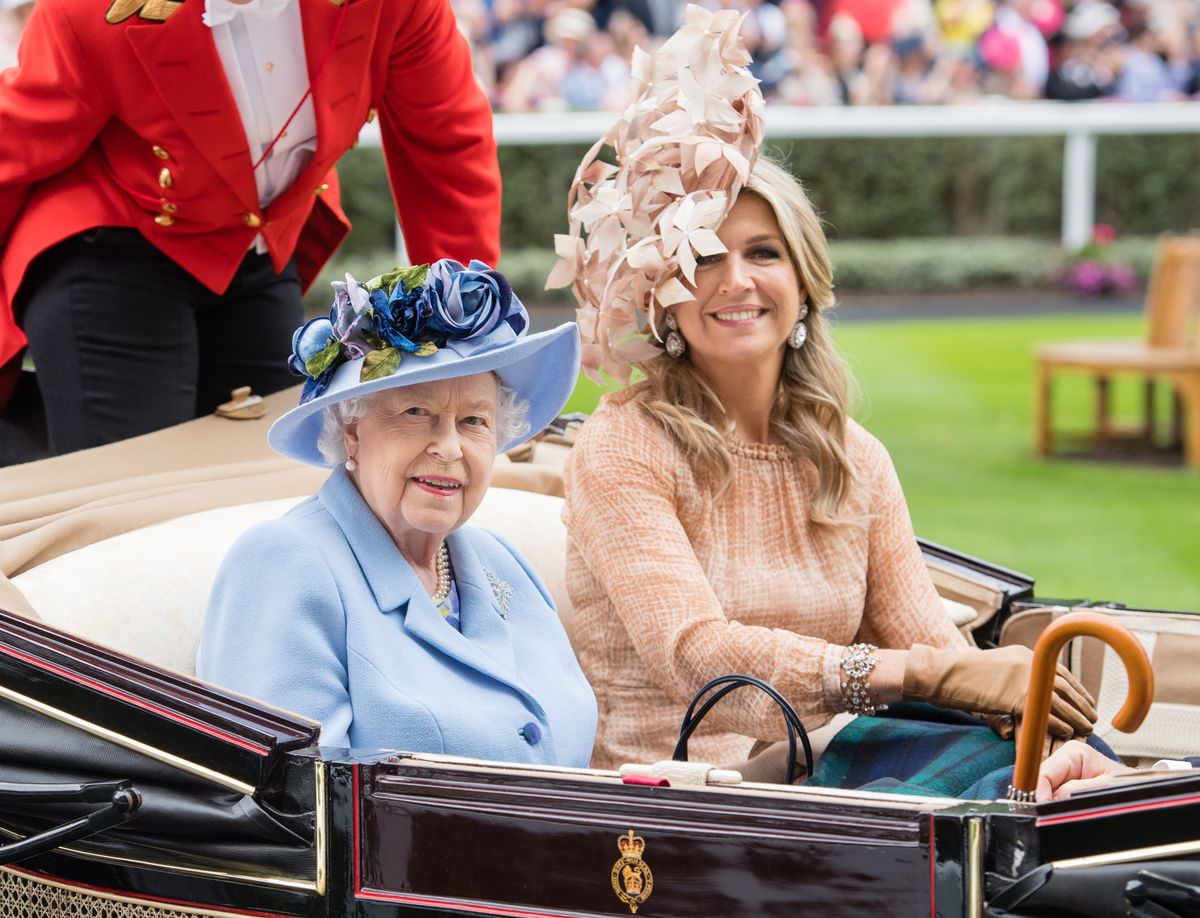 Queen Elizabeth II and Queen Máxima of the Netherlands arrive by carriage on the opening day of Royal Ascot on June 18, 2019, when Máxima debuts the dramatic gold laurel headpiece she later rewears at Amsterdam's WorldPride.