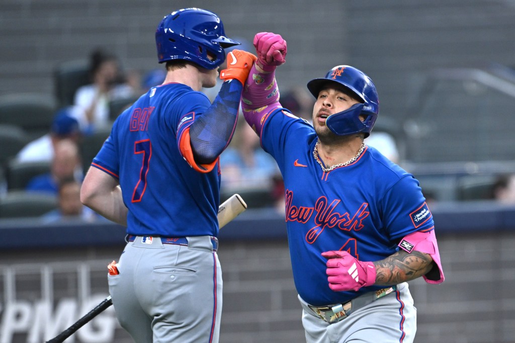 Francisco Alvarez high-fives Brett Baty after hitting a solo home run.