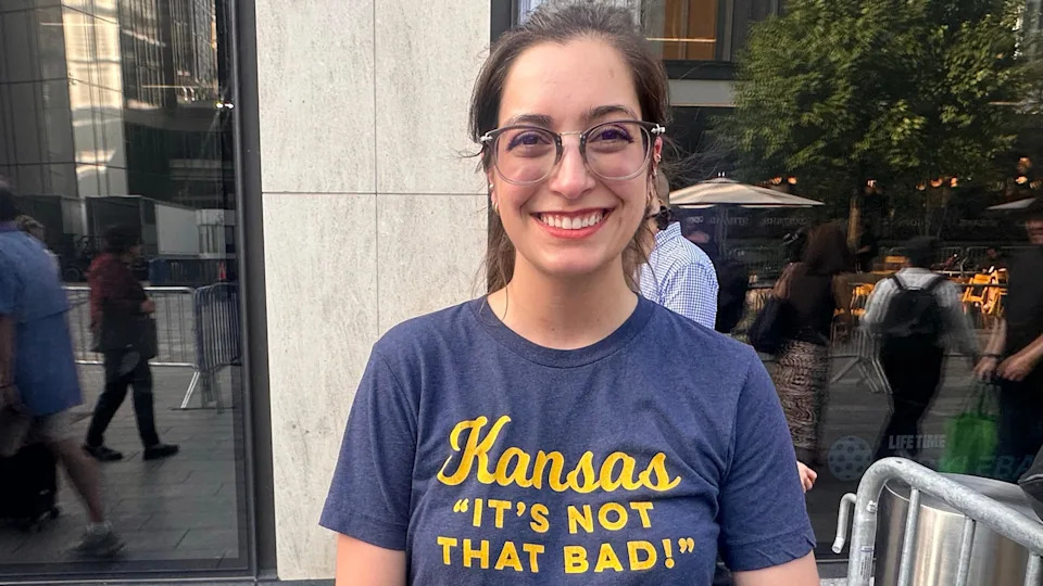 Rusty Carbaug is seen wearing a blue T-shirt that reads " Kansas, it's not that bad" 