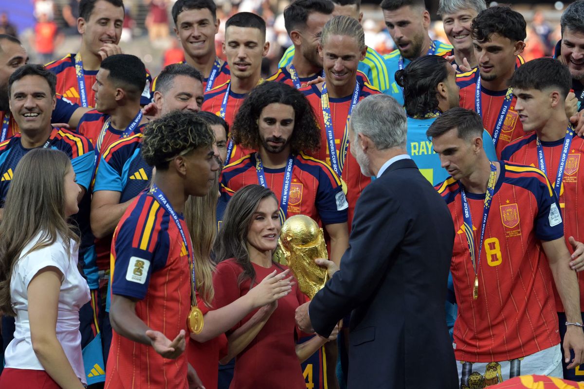 King Felipe VI hands the World Cup trophy to Queen Letizia as Spain celebrates its historic victory over Argentina. Lamine Yamal stands by the royal family's side during the trophy ceremony.