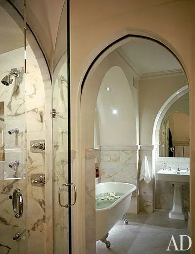 A series of Moorish pointed arches, repeated on the door of the steam shower and medicine chest, punctuates the bath, which Ciccone covered in rectangular pieces of Italian marble. The bathtub has silvered claw-and-ball feet.