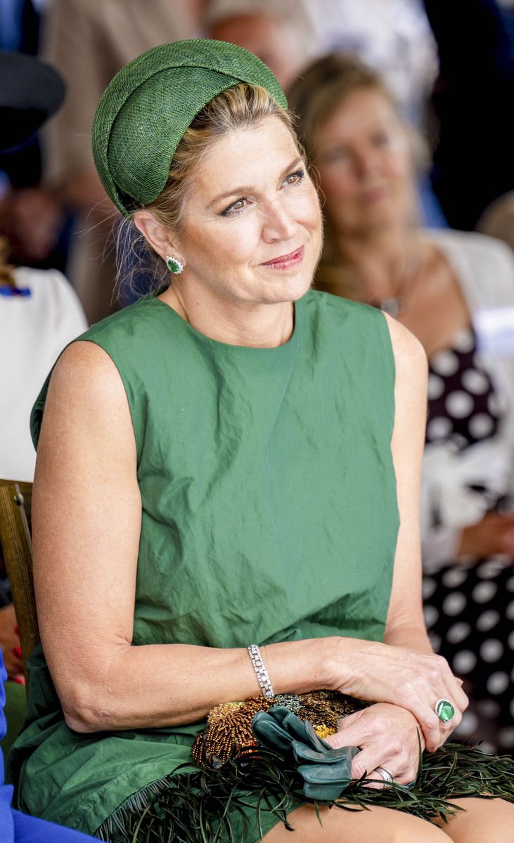 Queen Máxima completed her monochromatic ensemble with emerald gemstone earrings, a matching statement ring, and a polished beauty look.