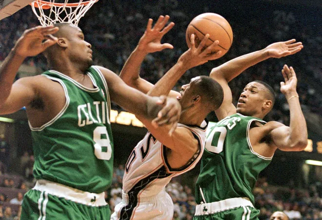 New Jersey Nets guard Kerry Kittles (C) is fouled as he drives between Boston Celtics players Antoine Walker (L) and Tony Battie (R) in the second quarter 27 February at Continental Airlines Arena in East Rutherford, N.J. AFP PHOTO/Matt CAMPBELL (Photo by MATT CAMPBELL / AFP) (Photo credit should read MATT CAMPBELL/AFP via Getty Images)