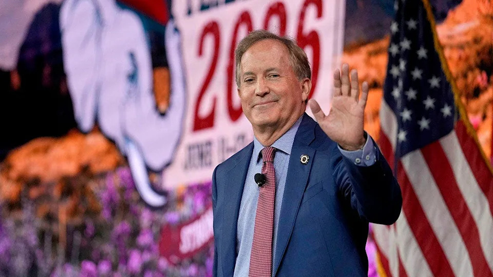 Ken Paxton smiles and waves