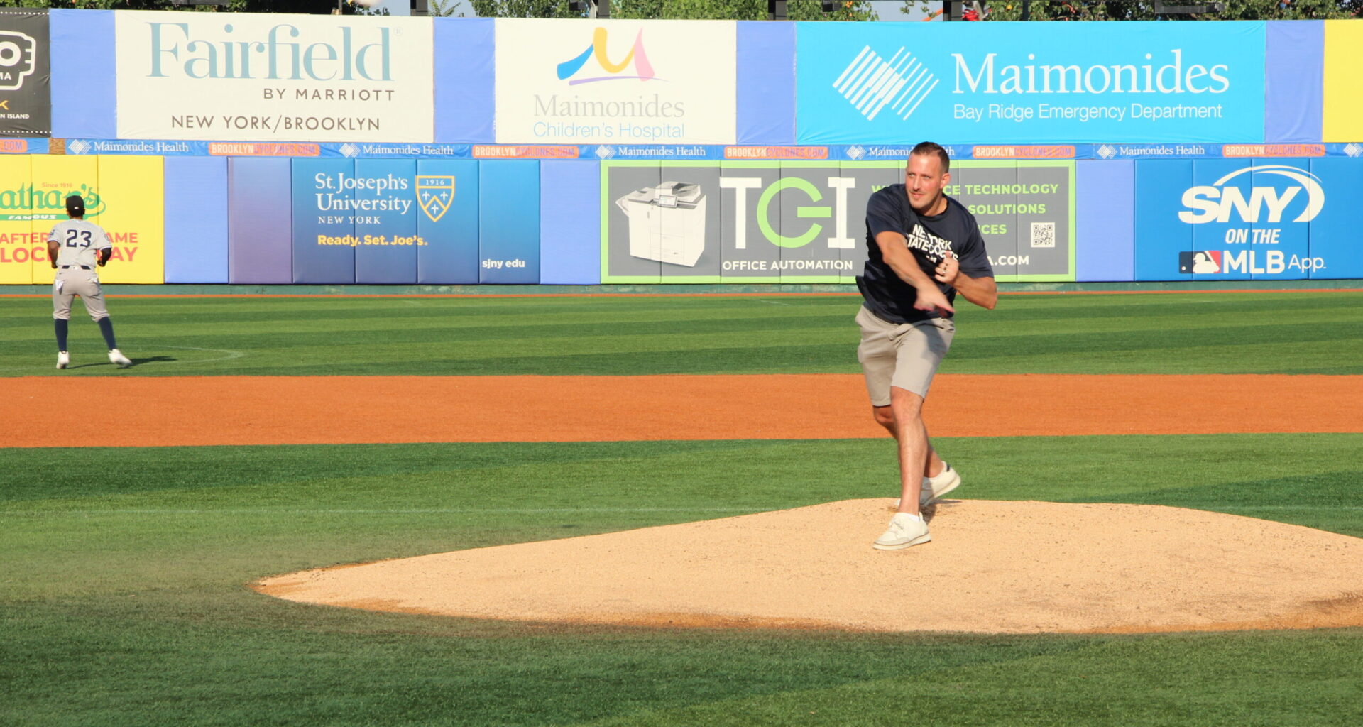 Mike Baccellieri, son of Chief Joe Baccellieri Jr., throws out one of the first pitches in honor of his father. Photo: Mario Belluomo/Brooklyn Eagle