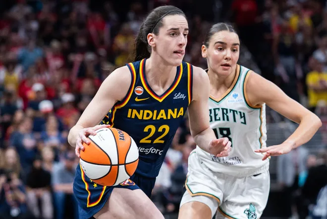 Jul 18, 2026; Indianapolis, Indiana, USA; Indiana Fever guard Caitlin Clark (22) dribbles the ball while New York Liberty guard Pauline Astier (18) defends in the first half at Gainbridge Fieldhouse. Mandatory Credit: Trevor Ruszkowski-Imagn Images