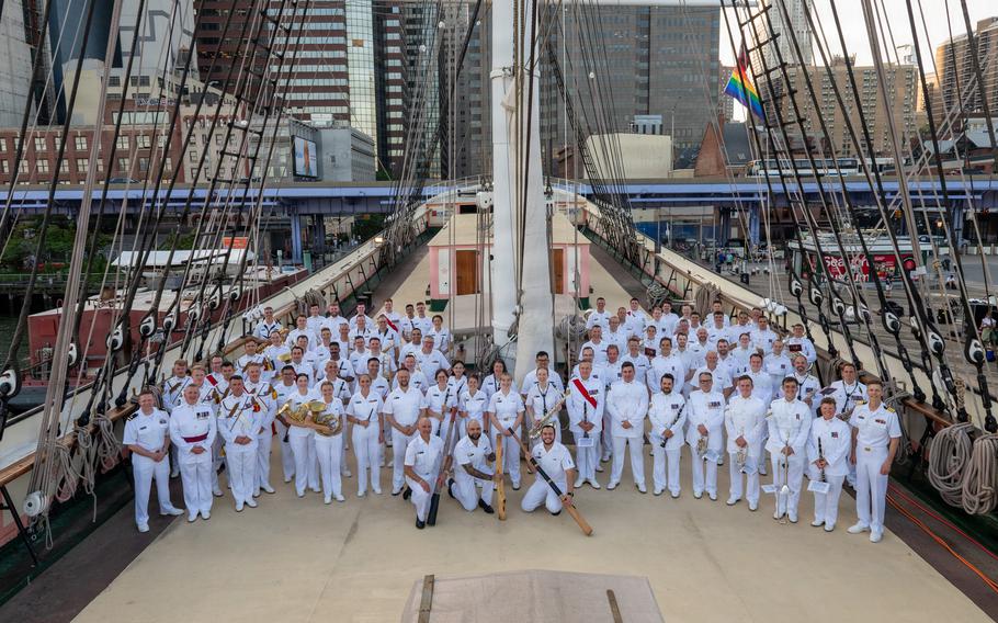 The band members pose for a photo on the deck of the ship.