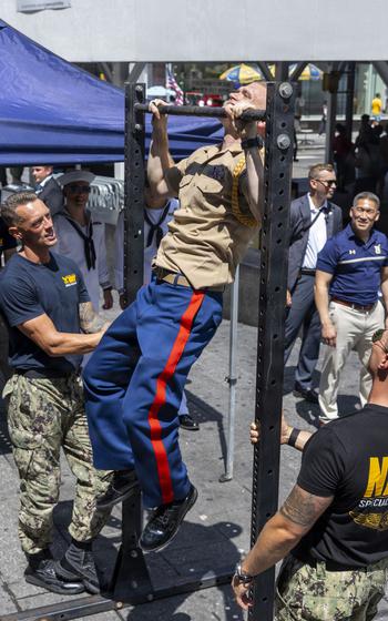 The Marine pulls himself up on the bar.