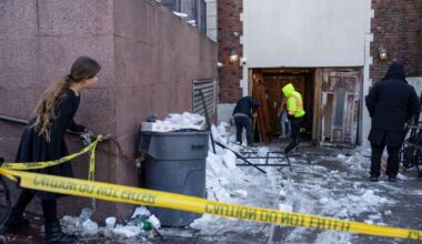 A person watches the scene where a car slammed into the entrance of the Chabad Lubavitch world headquarters, Thursday, Jan. 29, 2026, in Crown Heights. Photo: Yuki Iwamura/AP