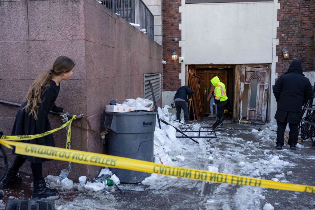 A person watches the scene where a car slammed into the entrance of the Chabad Lubavitch world headquarters, Thursday, Jan. 29, 2026, in Crown Heights. Photo: Yuki Iwamura/AP