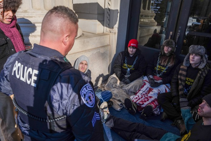 A University of Minnesota Police officer threatens student protesters with arrest