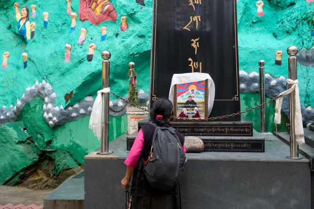 An exiled Tibetan pays her respects in front of a framed photograph of Lobga Rangzen (Lobsang Palden), who died after setting himself on fire in front of the United Nations headquarters in New York on Thursday, in Dharamshala, India, Saturday, July 4, 2026. (AP Photo/Ashwini Bhatia)