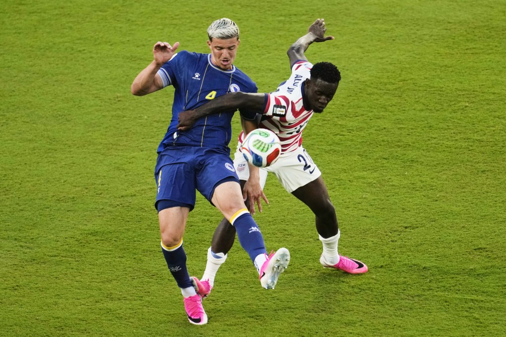 Folarin Balogun and Tarik Muharemovic challenge for the ball.
