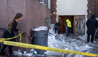 People clean up after a car slammed into the entrance of the Chabad Lubavitch world headquarters, Jan. 29, 2026, in New York. (AP Photo/Yuki Iwamura, File)