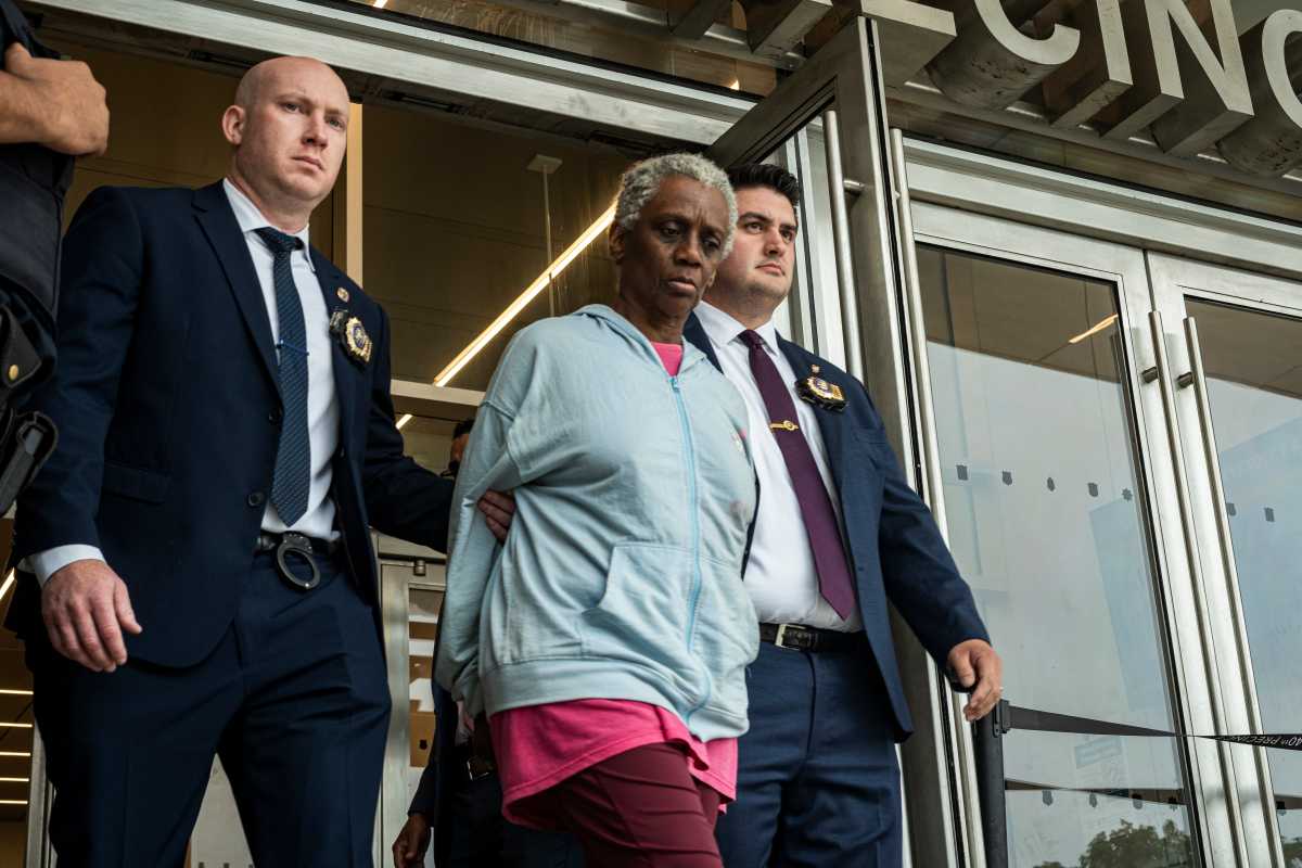 police escort Bronx woman in handcuffs out of precinct stationhouse after being charged with murder of autistic boy