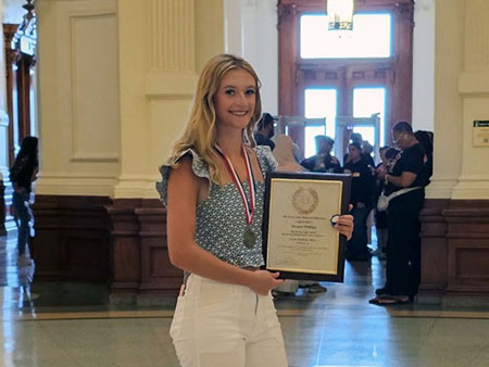 Bergan Pinkley holding Texas Hero award