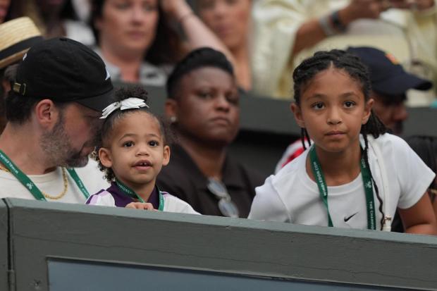 Serena Williams' husband Alexis Ohanian and their daughters Olympia and Adira watch her play.