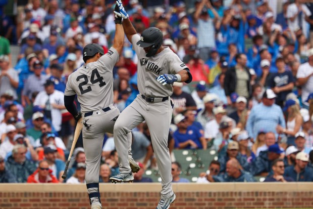 Yankees third baseman Amed Rosario, right, high-fives Jasson Domínguez (24) after hitting a solo home run in the top of the fourth inning against the Cubs on Friday, July 31, 2026, at Wrigley Field. (Stacey Wescott/Chicago Tribune)