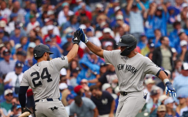 Yankees third baseman Amed Rosario, right, high-fives Jasson Domínguez after hitting a solo home run in the top of the fourth inning against the Cubs on Friday, July 31, 2026, at Wrigley Field. (Stacey Wescott/Chicago Tribune)