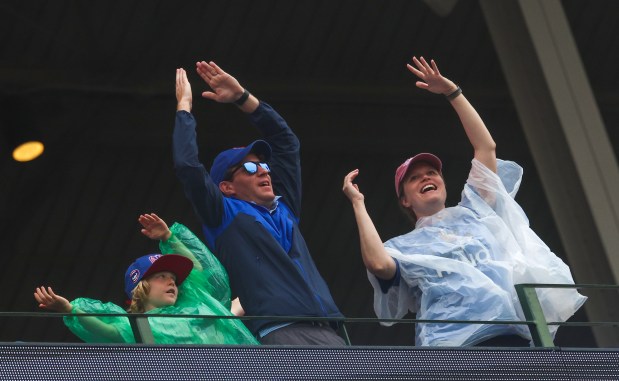 Despite the rain, fans stand and sing along with "YMCA" during a Cubs-Yankees game Friday, July 31, 2026, at Wrigley Field. (Stacey Wescott/Chicago Tribune)