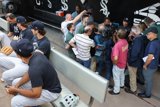Yankees manager Aaron Boone answers reporters' questions as players sit in the dugout before a game against the White Sox at Rate Field on July 28, 2026, in Chicago. (John J. Kim/Chicago Tribune)