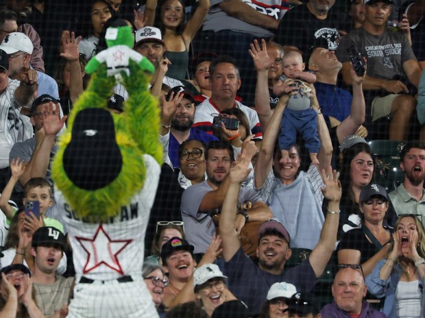 A woman hoists an infant to mimic White Sox mascot Southpaw hoisting a stuffed animal in his likeness in the seventh inning of a White Sox-Yankees game at Rate Field on July 28, 2026, in Chicago. (John J. Kim/Chicago Tribune)