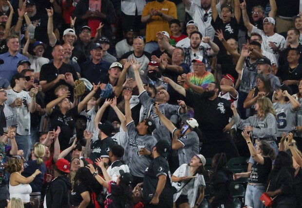 Fans reach for a two-run home run ball hit by White Sox second baseman Chase Meidroth in the ninth inning against the Yankees at Rate Field on July 28, 2026, in Chicago. (John J. Kim/Chicago Tribune)