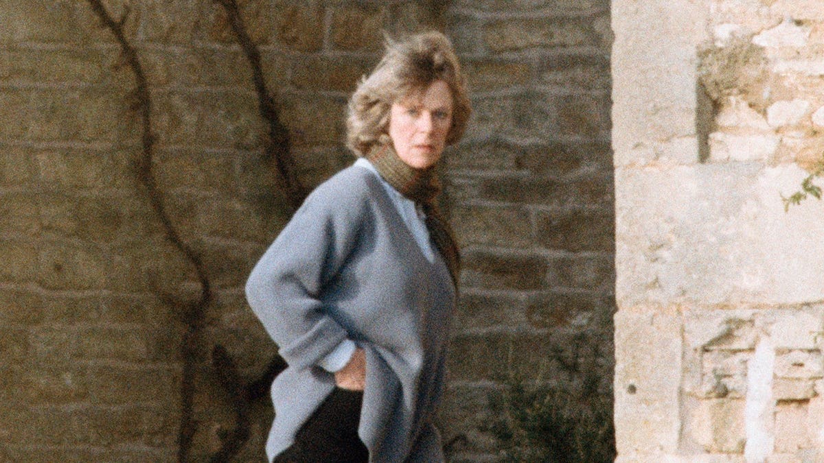 Camilla Parker-Bowles stands outdoors at home in campaign clothing.