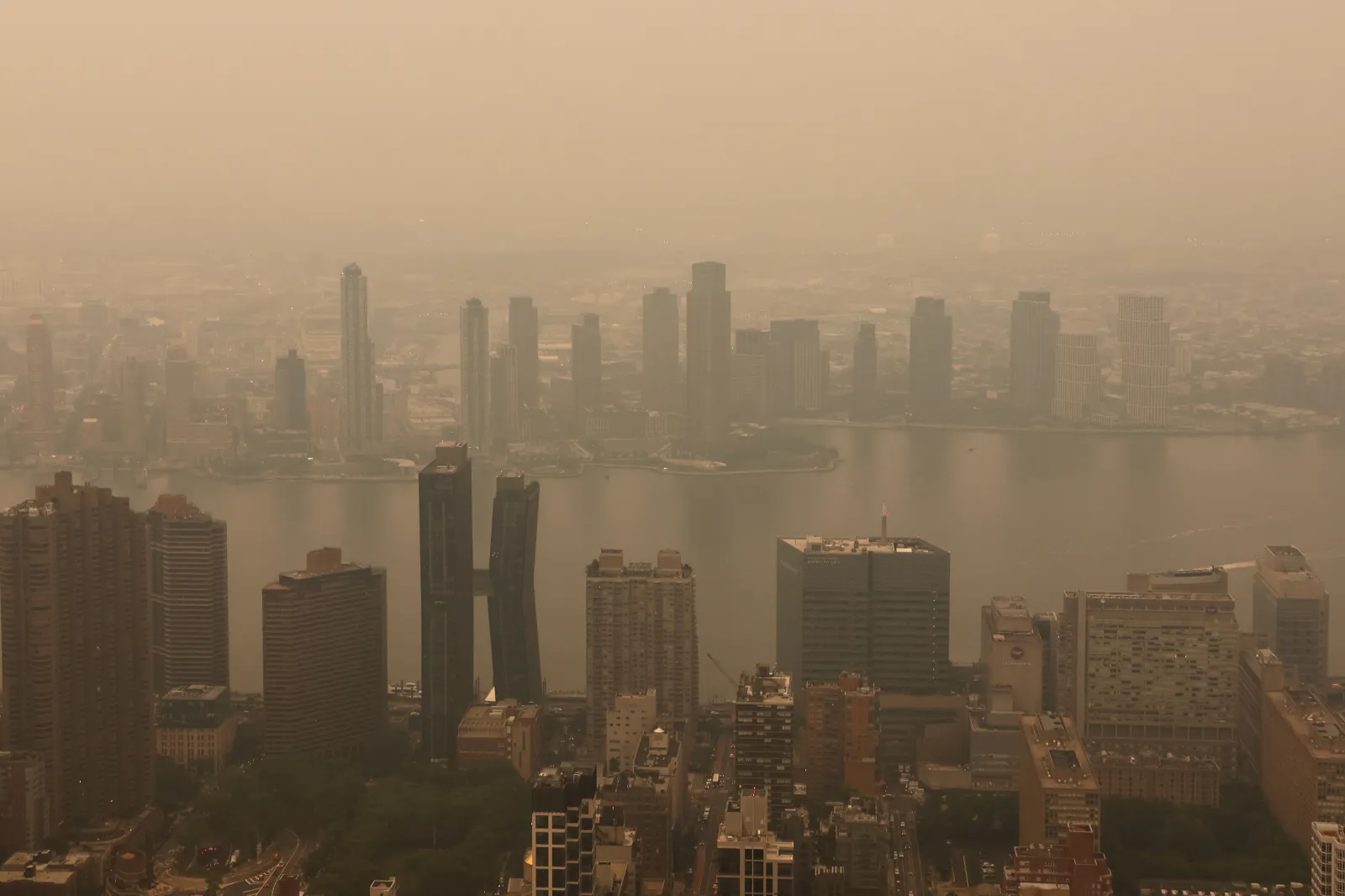 Smoke from wildfires in Canada shrouds the view east to the East River, seen from the 86th-floor observation deck of the Empire State Building before sunset on July 15, 2026, in New York City. | Photo by Gary Hershorn/Getty Images