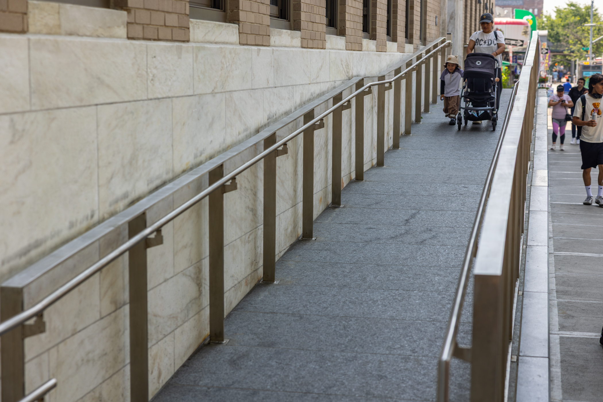 a woman pushes a stroller down a ramp