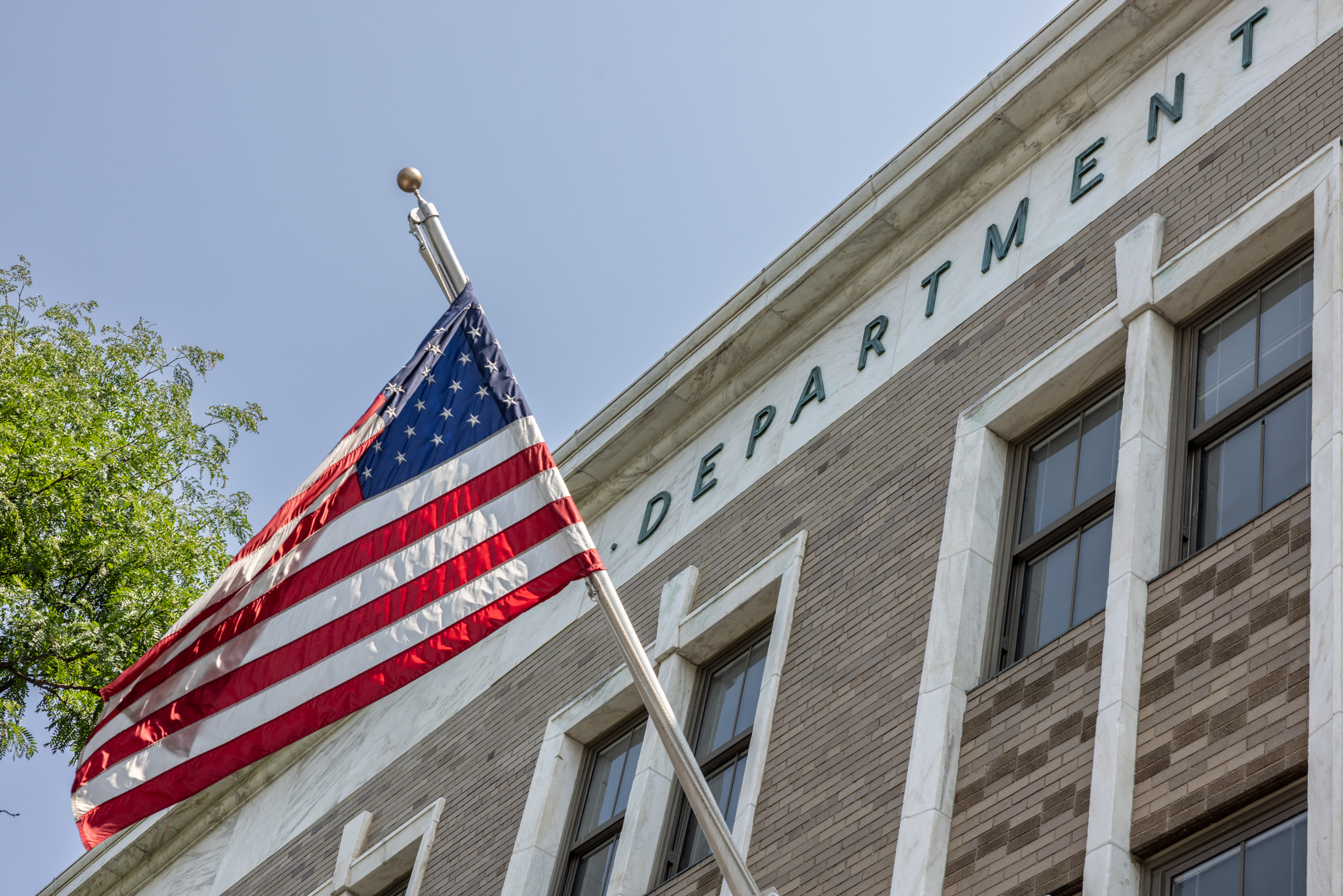American flag waves outside building