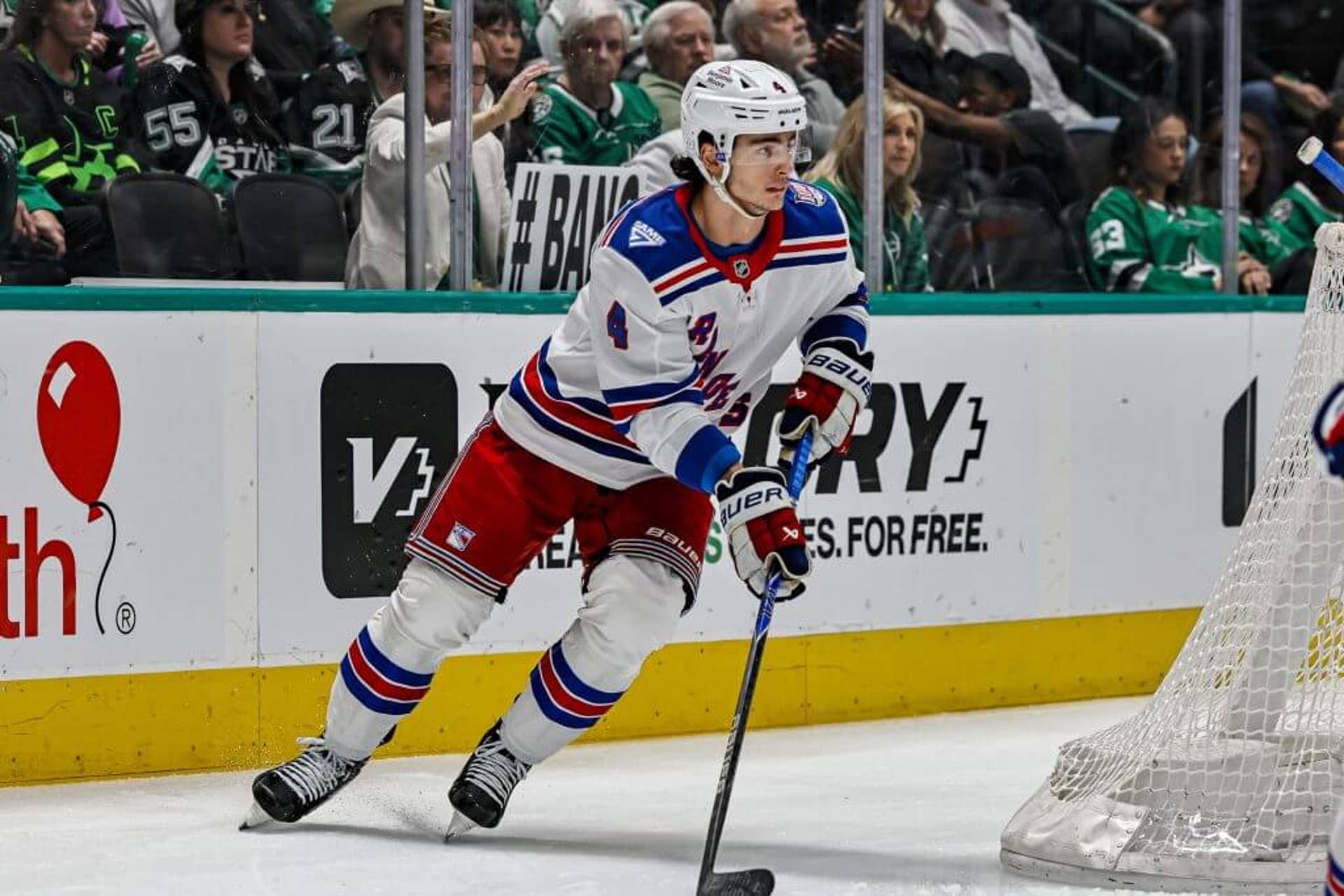 Braden Schneider skates with the puck behind the Rangers' net during a road game late in the 2025-26 NHL season.