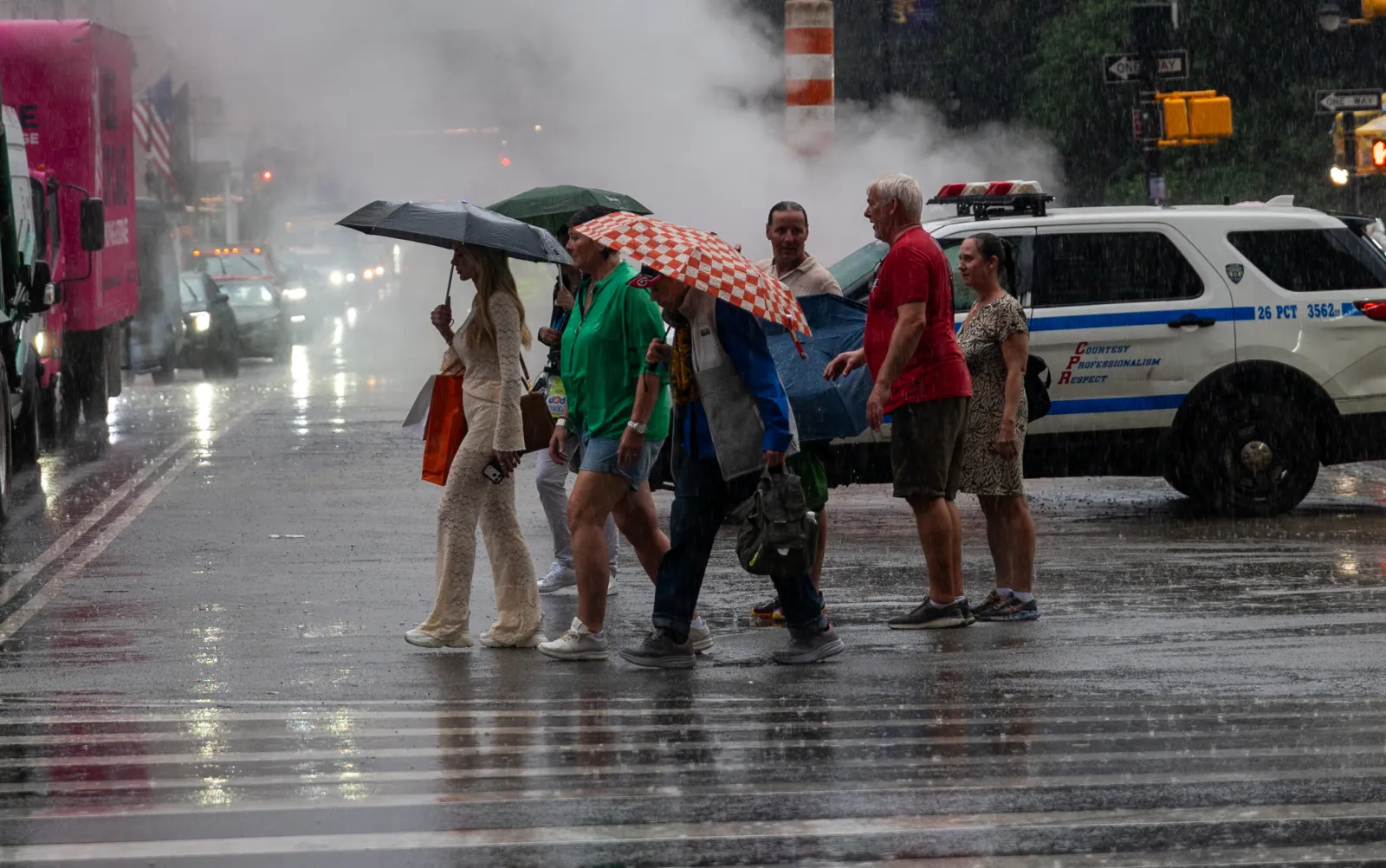 People walk through the rain along 5th Avenue in Manhattan on June 22 in New York City. (Photo by Spencer Platt/Getty Images)